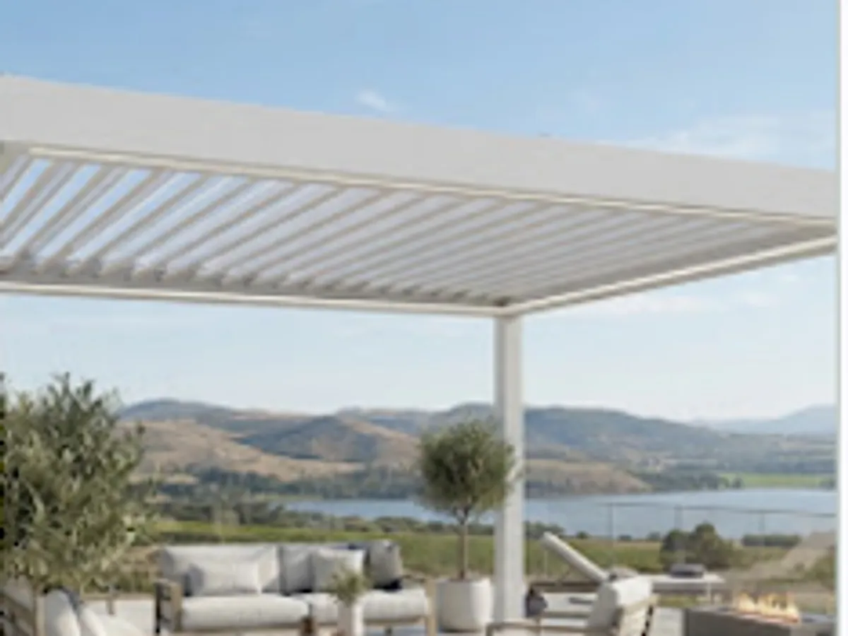 Döşenmiş bir terasın üzerinde, alüminyum lamelleri açık bir biyoklimatik pergola.